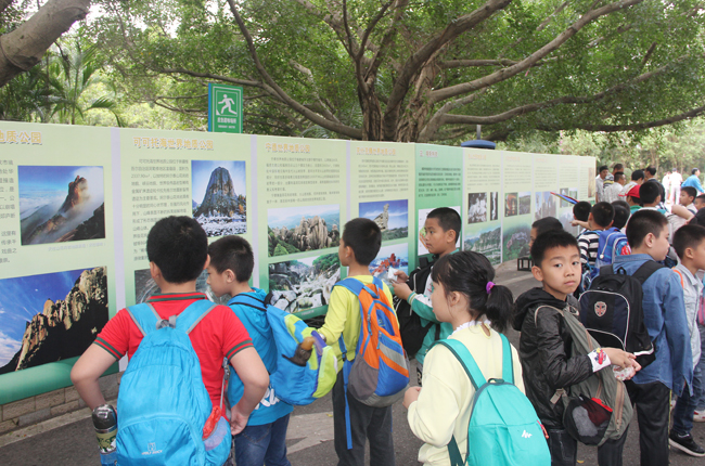 (3)參加活動的學生們饒有興趣地在雷瓊公園三嶺山景區觀看中國的世界地質公園圖片展.jpg